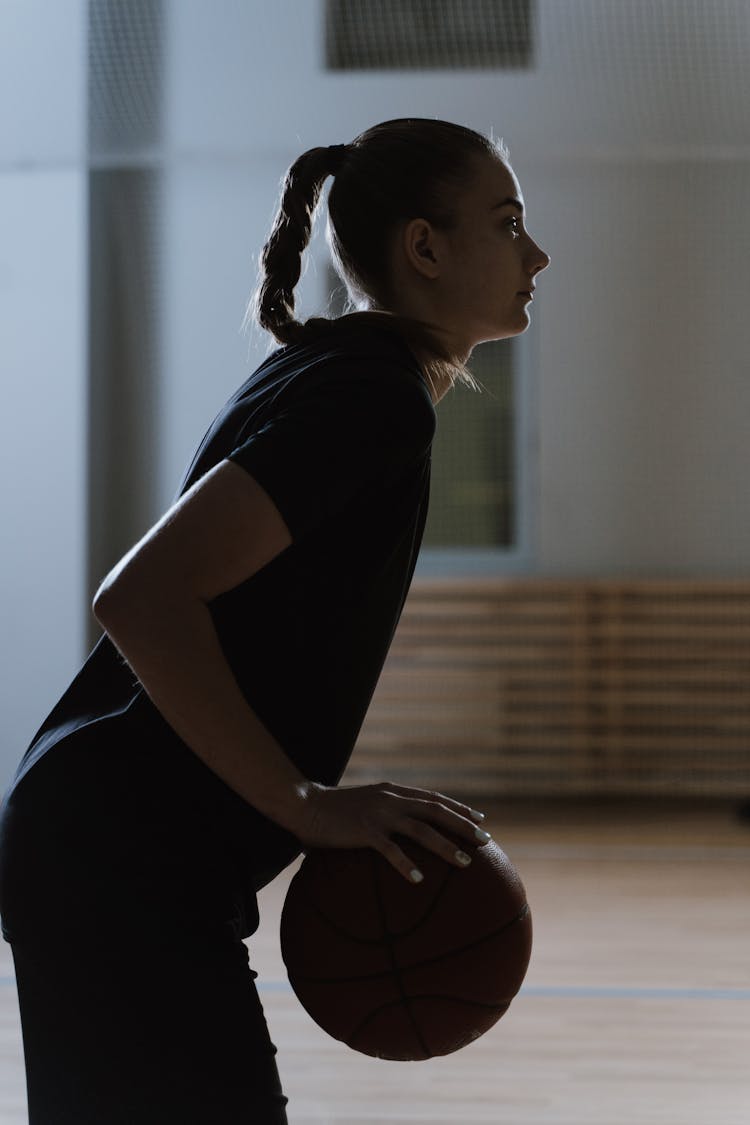 Side View Of Woman Holding Brown Ball