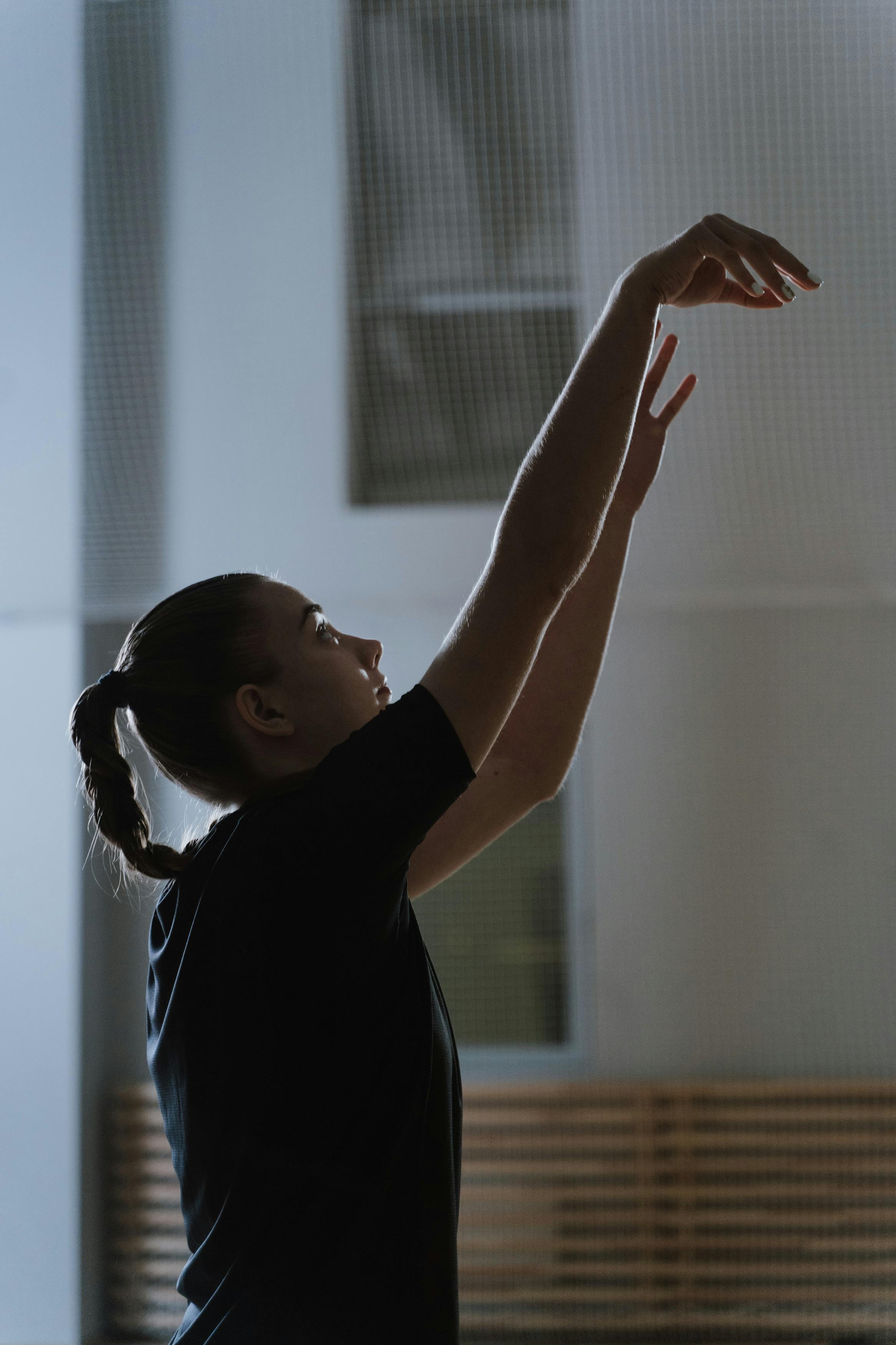 woman in black shirt raising her hands