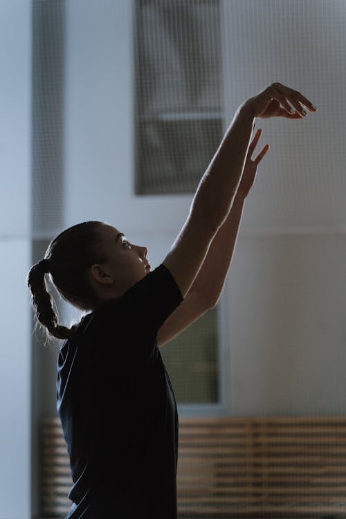 Woman in Black Shirt Raising her Hands