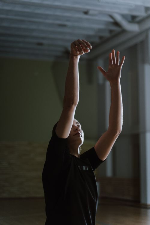 Free A young athlete in an indoor court practices a basketball shot. Stock Photo