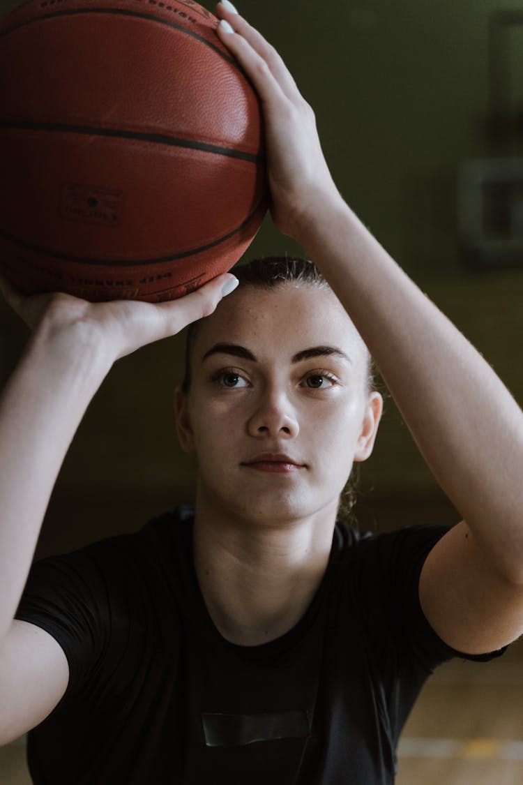 A Woman Shooting A Basketball