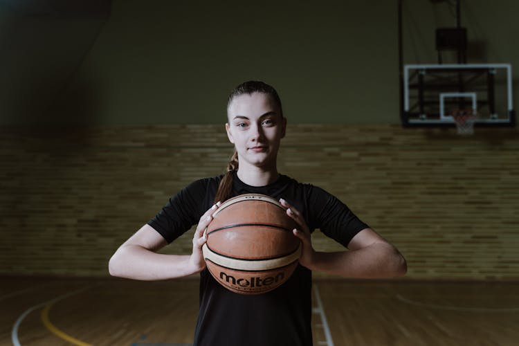 Woman Holding Basketball On Court