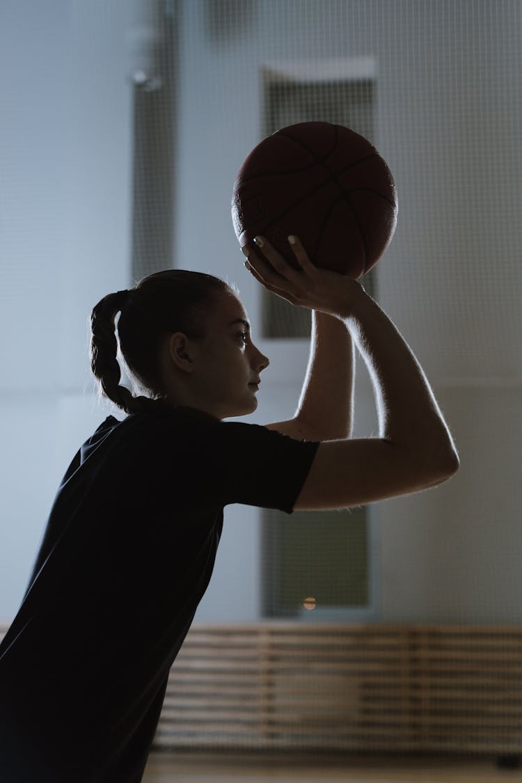 Young Woman Shooting A Basketball