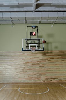 Indoor basketball hoop with shot clock, minimalist court design.