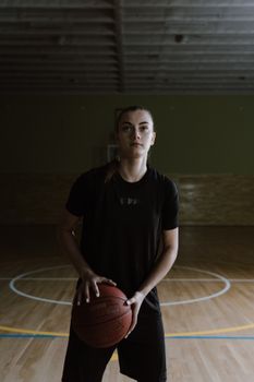 Portrait of a young female basketball player in a gym ready to play.