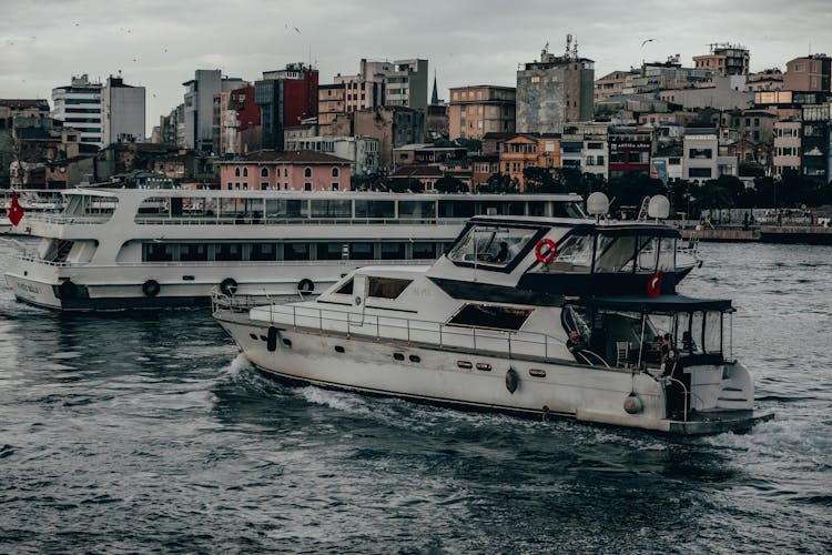 Boat And Cruise Ship Floating On Sea