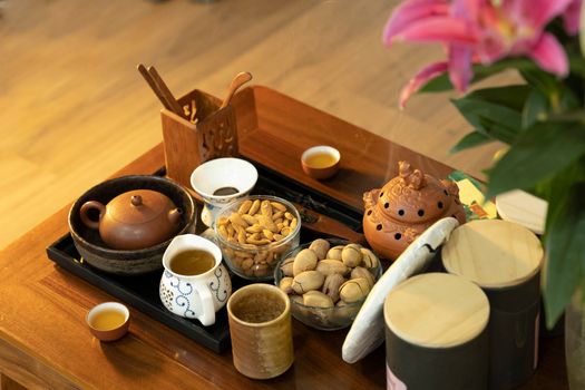 A beautifully arranged tea set with snacks on a wooden tray, perfect for an inviting tea time.