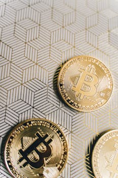 Close-up of golden Bitcoin coins on a modern geometric pattern background symbolizing cryptocurrency wealth.