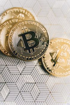 Close-up of Bitcoin coins placed on a geometric patterned surface, representing cryptocurrency and finance.