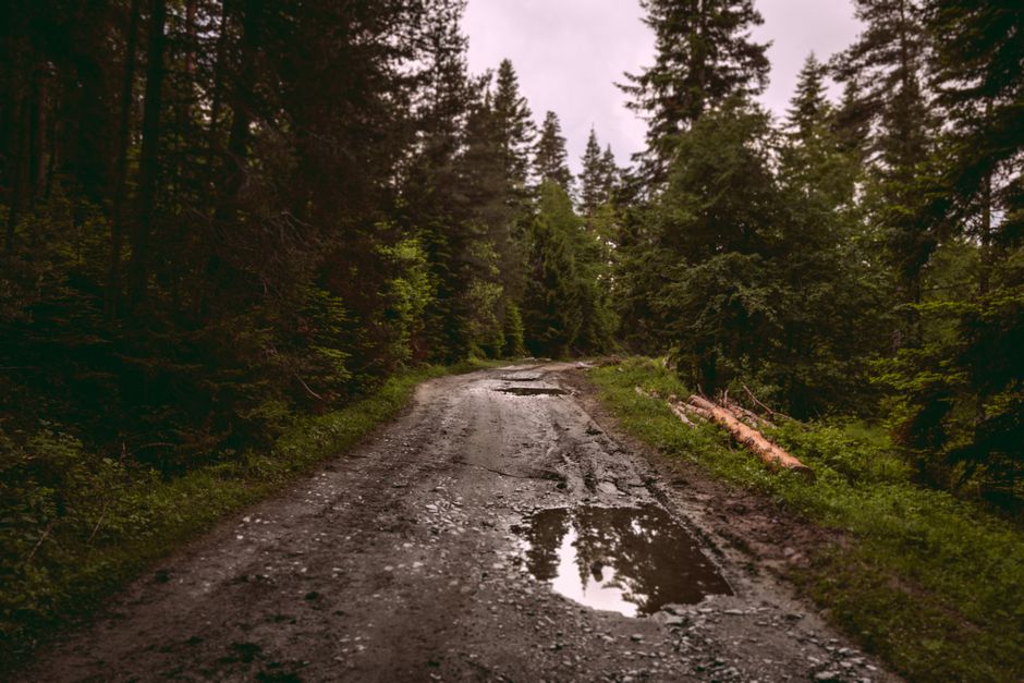 A rural road in Moldova with visible potholes, indicating caution