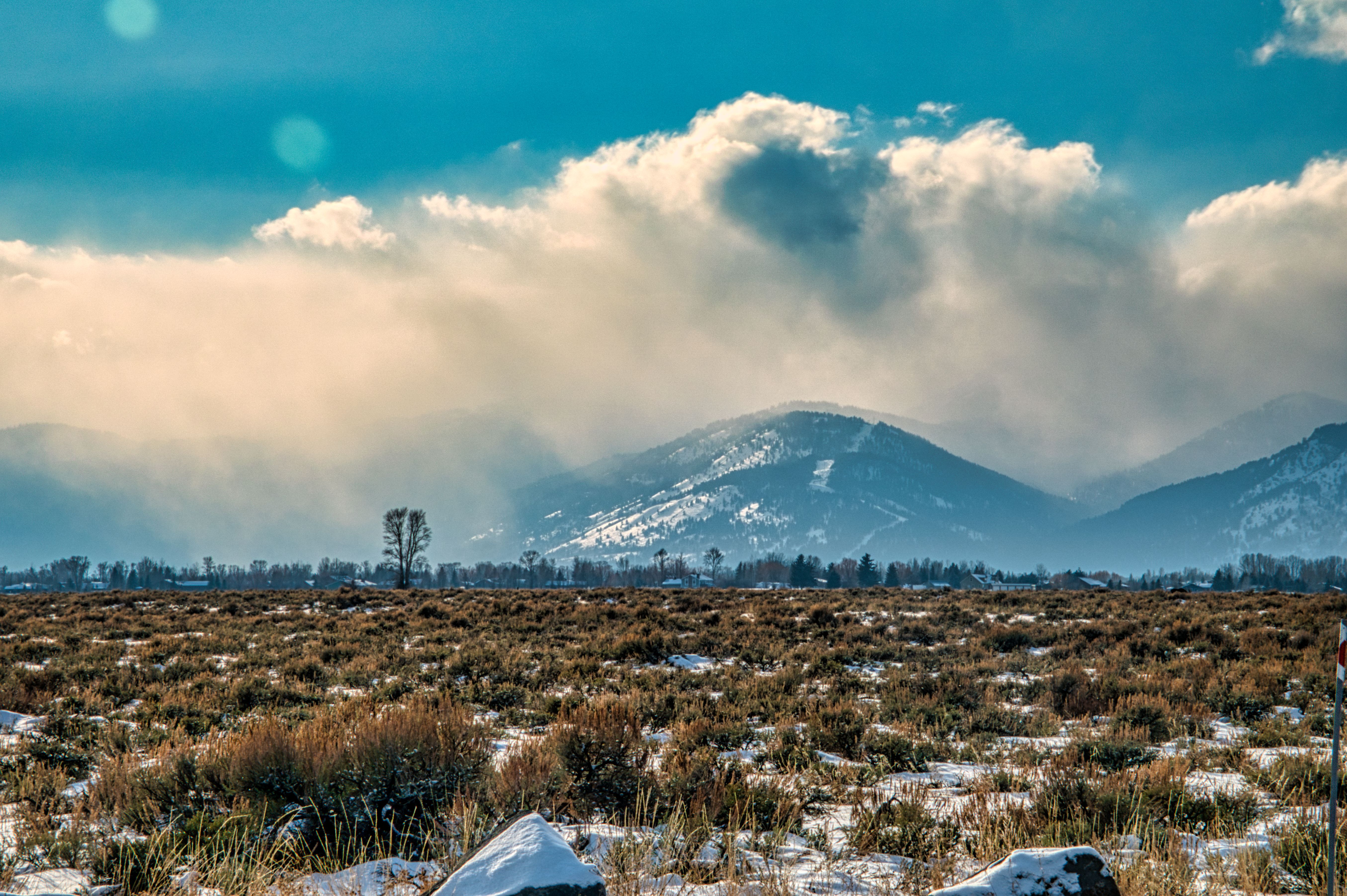 Scenic view of Grand Teton mountains with snow and dramatic clouds in WY.