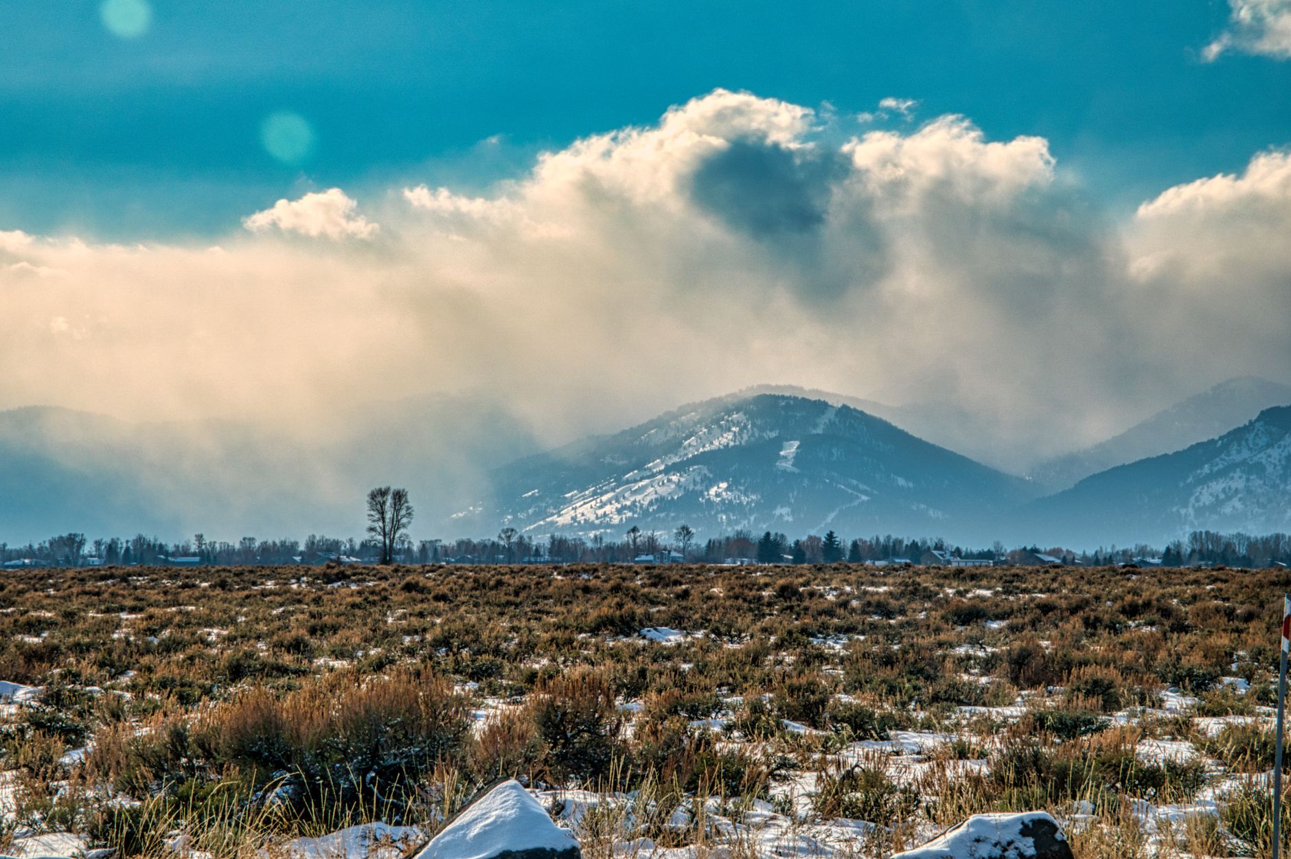 Scenic view of Grand Teton mountains with snow and dramatic clouds in WY.