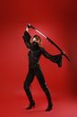 Model in black mask with katana on red background