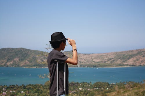 Man in a Hat Looking at the View with Water