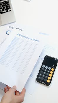 Business summary sheet with a calculator on a desk for financial analysis.