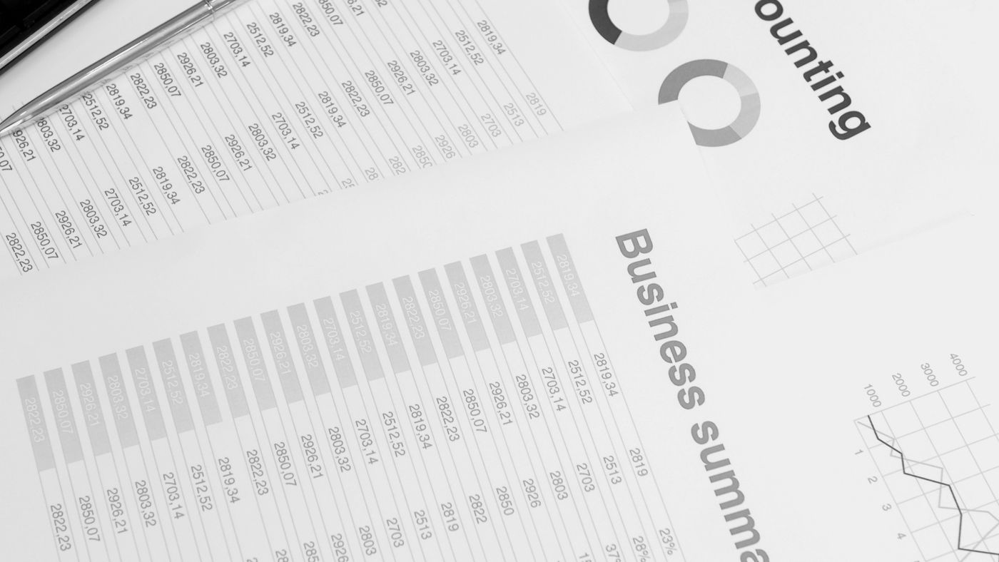 Readable columns on paper are not proof of correctly extracted spreadsheet cells. Photo: Artem Podrez / Pexels; illustrative printed report. Black-and-white close-up of printed accounting tables, charts and a business summary