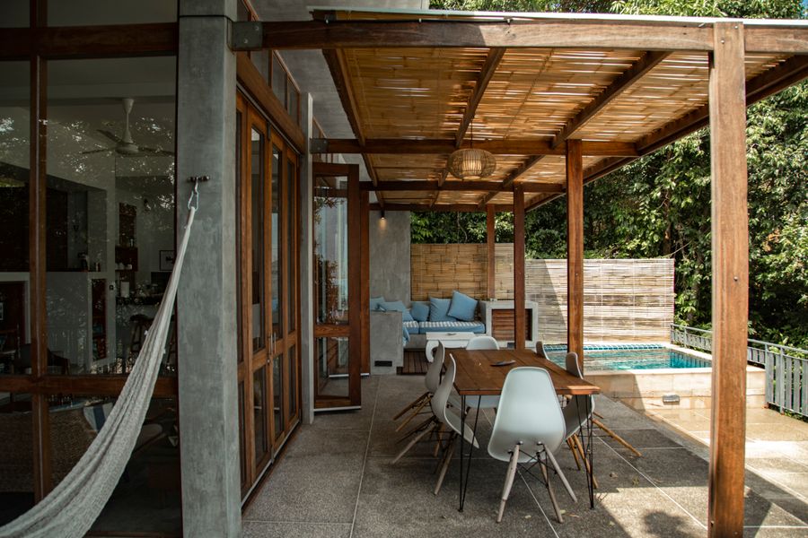 An elegant terrace with a pergola and pool at dusk