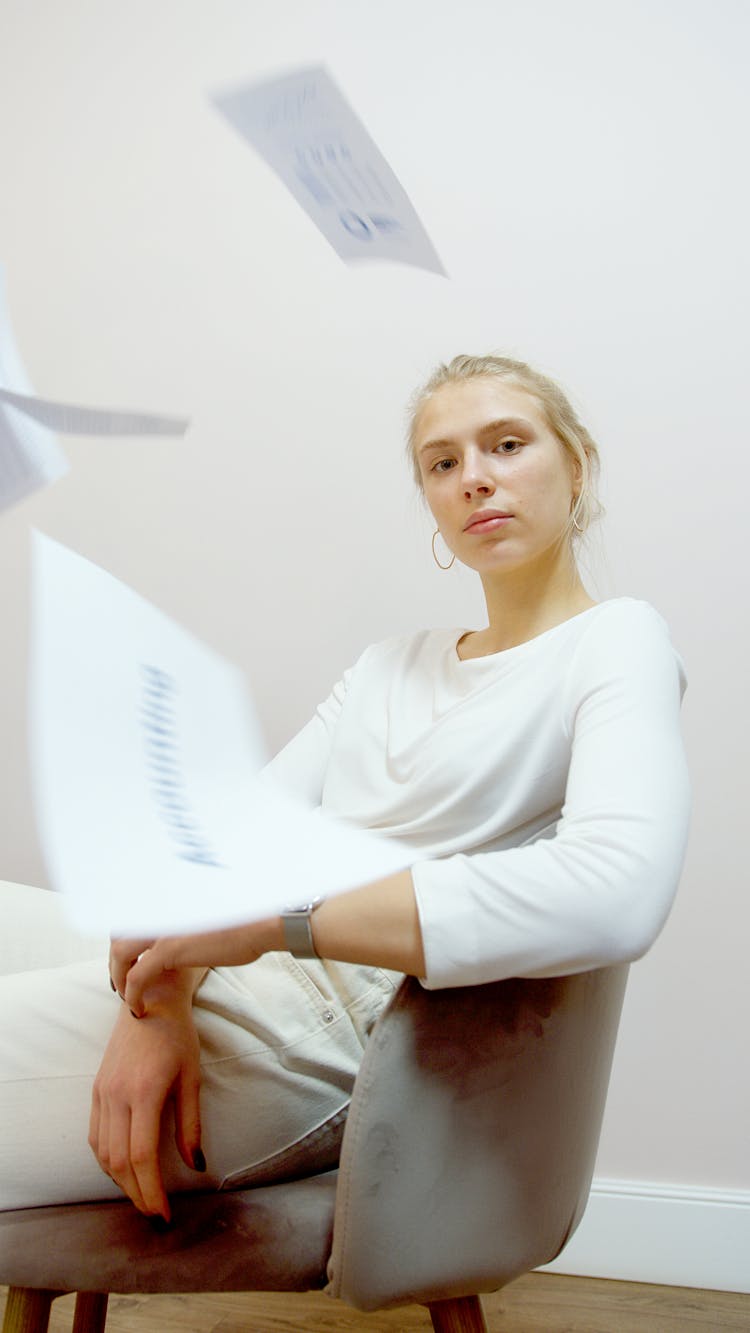 Woman In White Long Sleeve Shirt Sitting  On Brown Chair