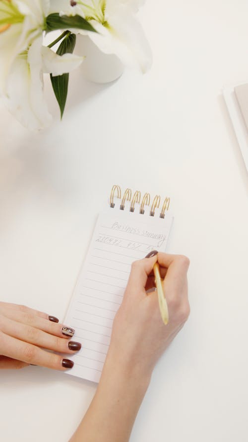 Woman Writing on a Notepad