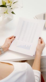 An overhead view of a person reviewing financial documents with graphs.