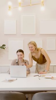 Two women collaborating on a project in a stylish modern office setting.