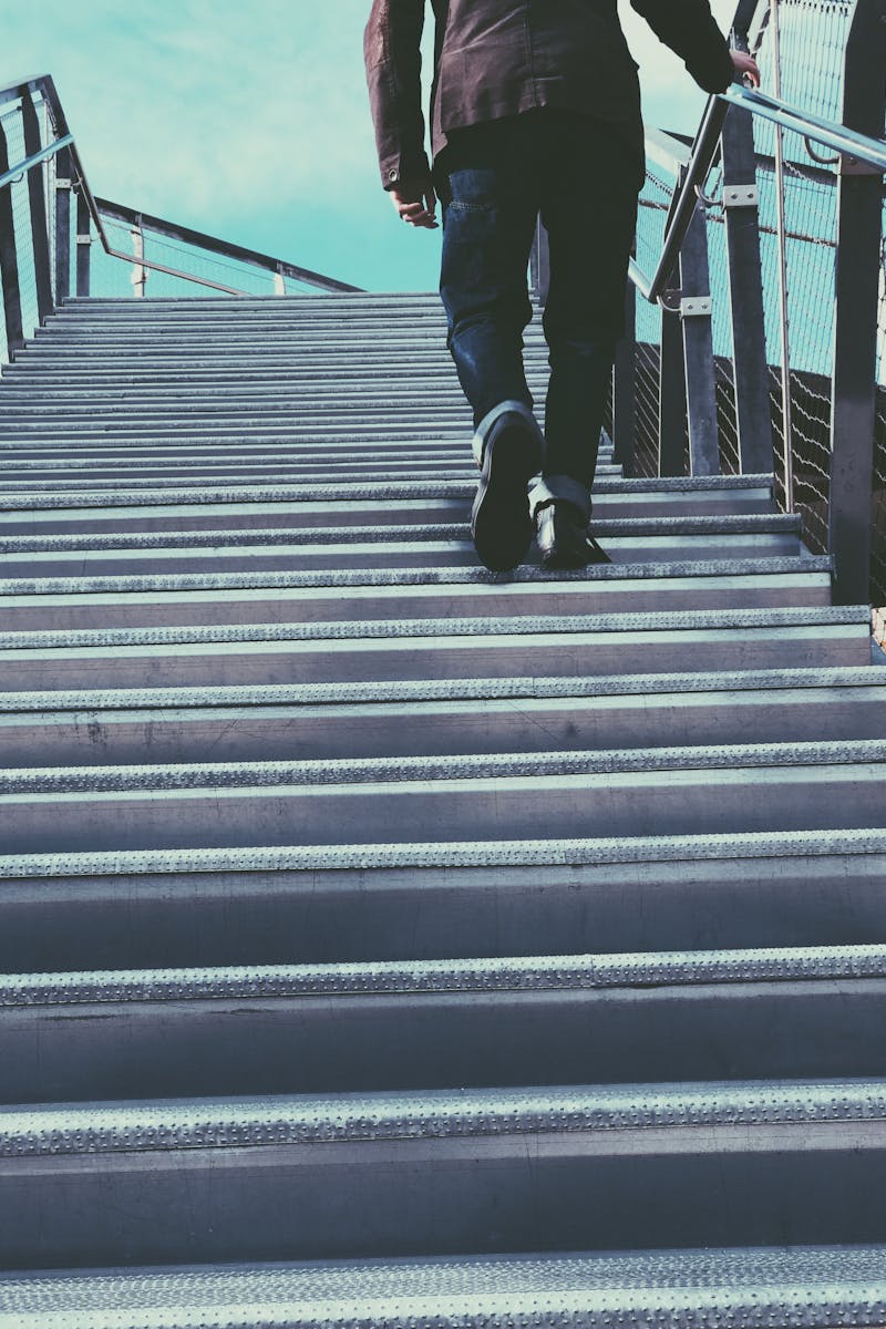 Man Walking on Gray Stairs