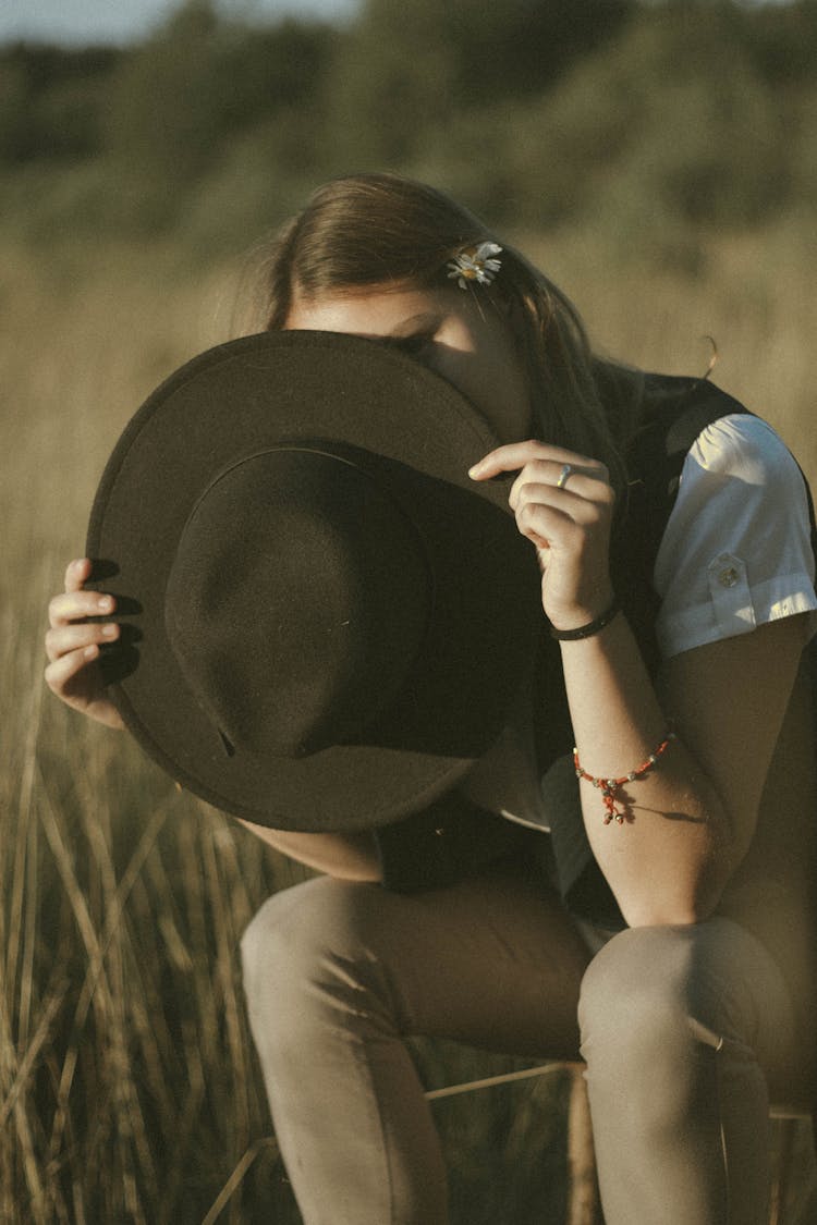 Unrecognizable Female Hiding Face Behind Hat