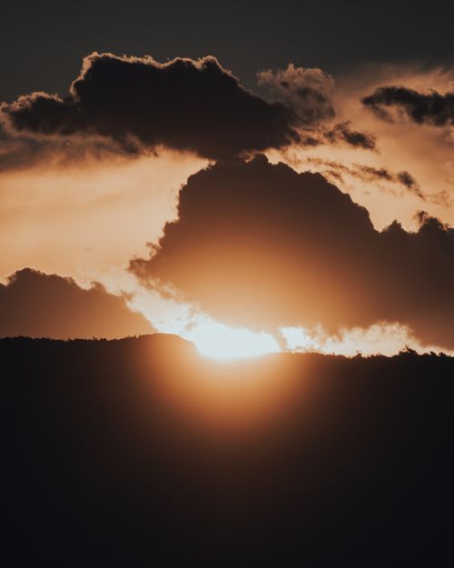 Free Capture of a stunning sunset with golden clouds creating a serene atmosphere. Stock Photo