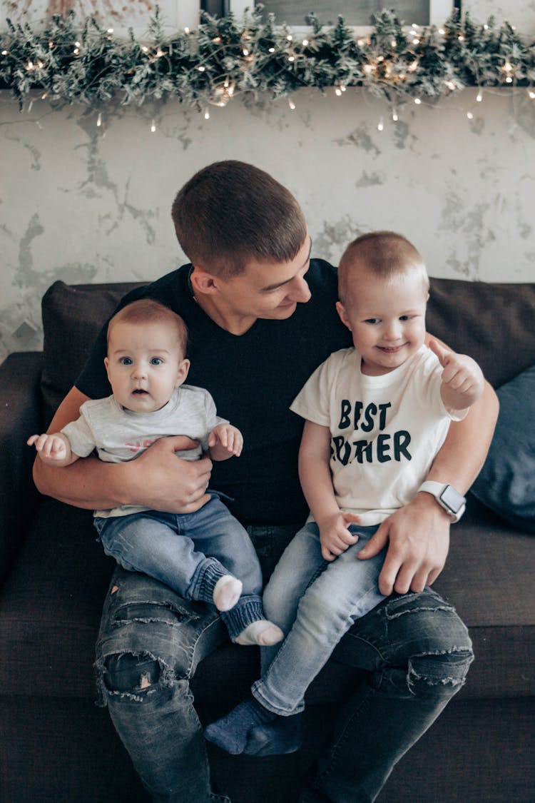 Happy Father With Baby And Kid On Couch