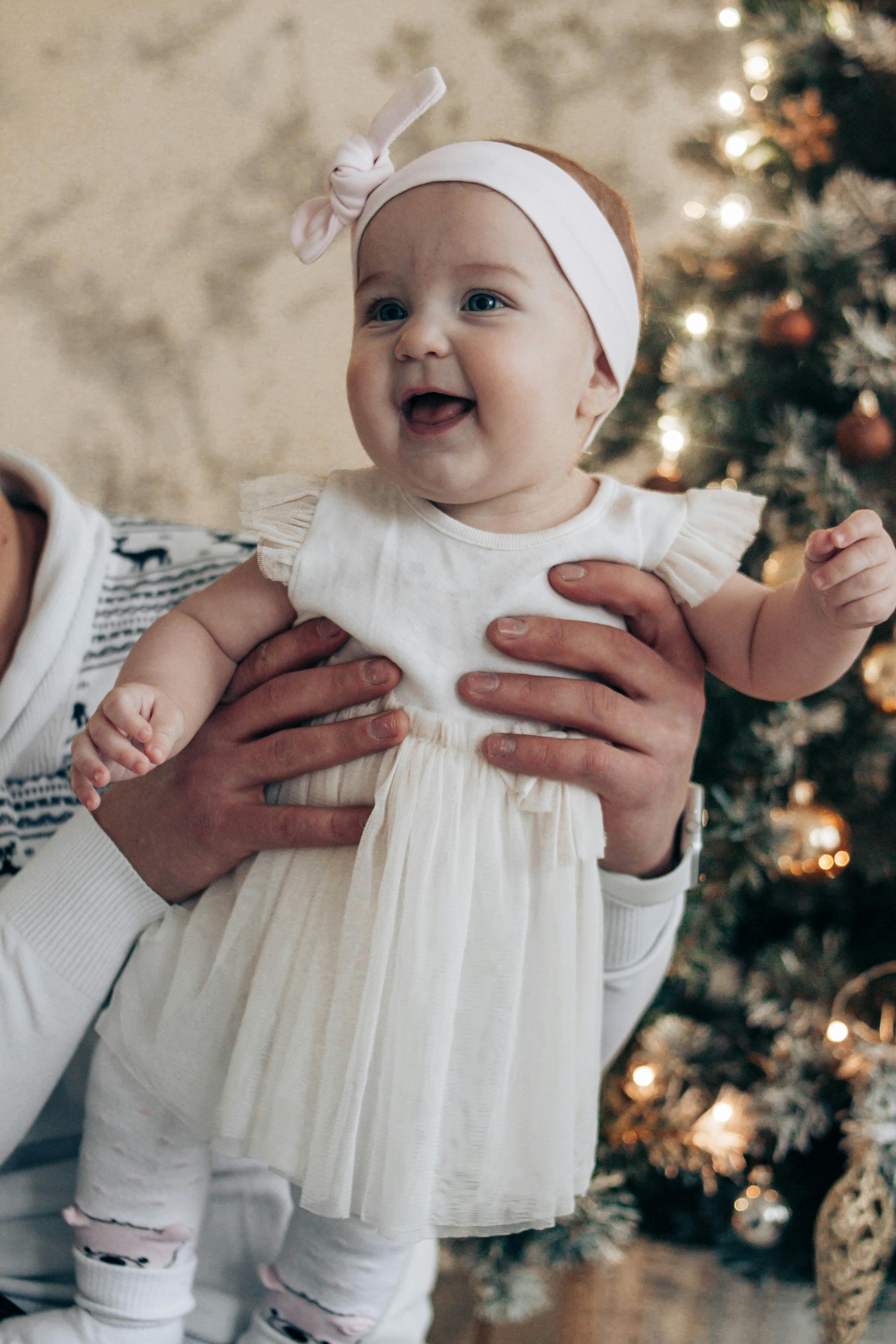 little baby in hands of father near christmas tree