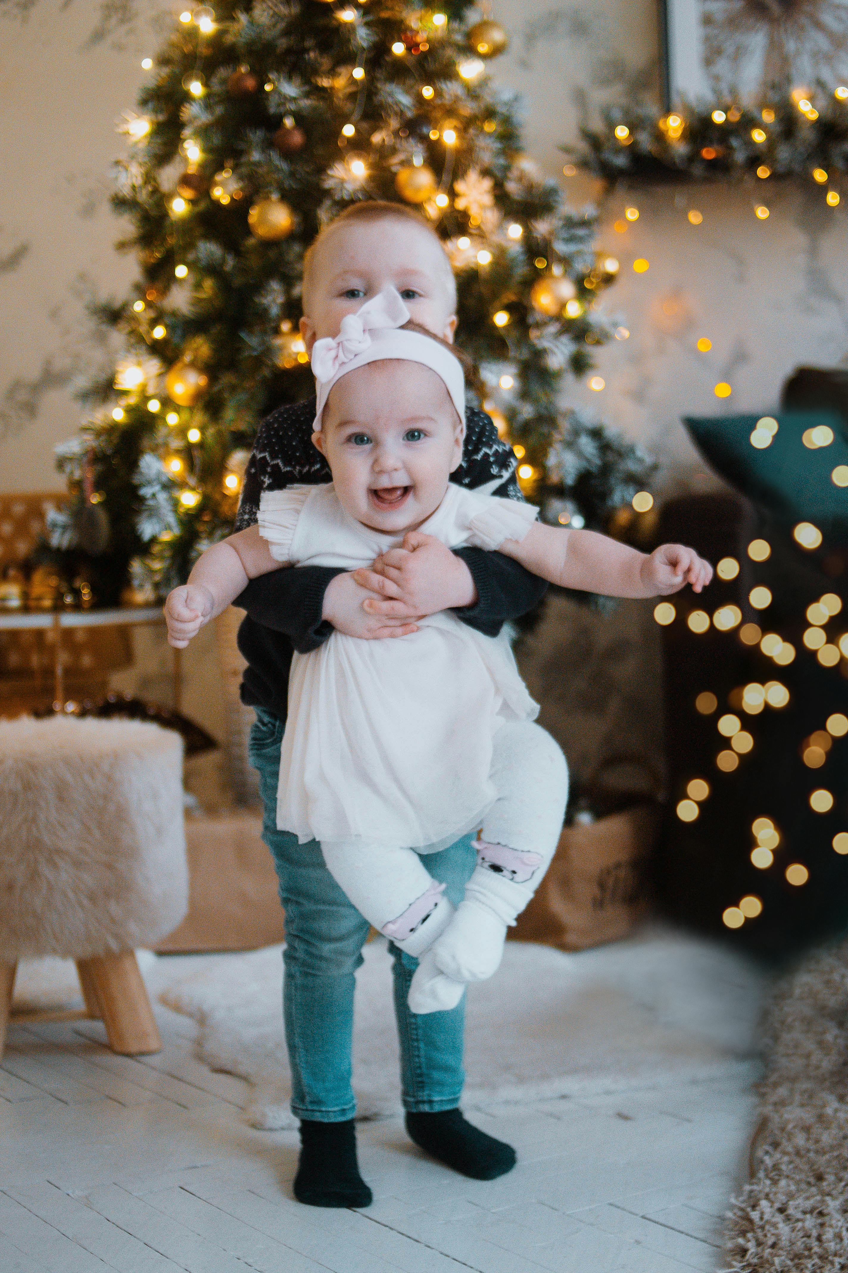 children near christmas tree with decorations and garlands in room