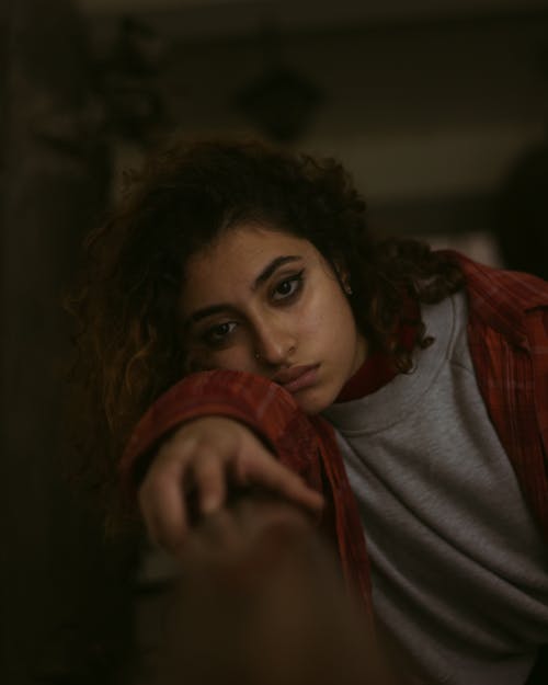 Ethnic female leaning on railing in room