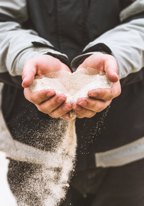 Man pouring sand from hands in nature