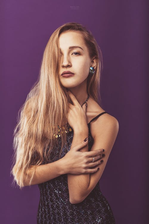 Alluring woman with long hair standing in studio