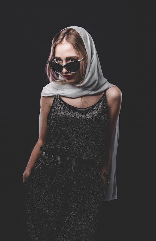 Fashionable independent blond woman in dark studio