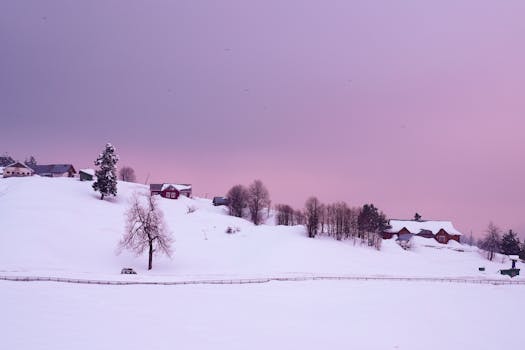 Beautiful snow-covered hills and houses in Gulmarg during a tranquil twilight.