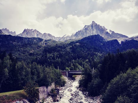 A scenic landscape of the mountains, river, and bridge in Haute-Savoie, France.