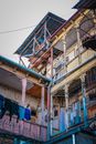 From below of aged weathered colorful apartment construction in poor areas of city with opened balconies and clotheslines