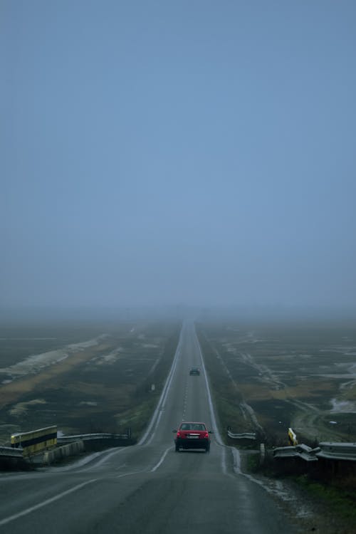 Asphalt highway with cars in fog