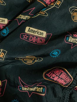 Details of trendy cotton shirt with colorful retro styled inscriptions and logos of American diners