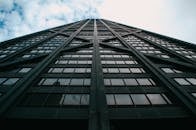 在芝加哥市中心多云天空下，仰视现代玻璃摩天大楼