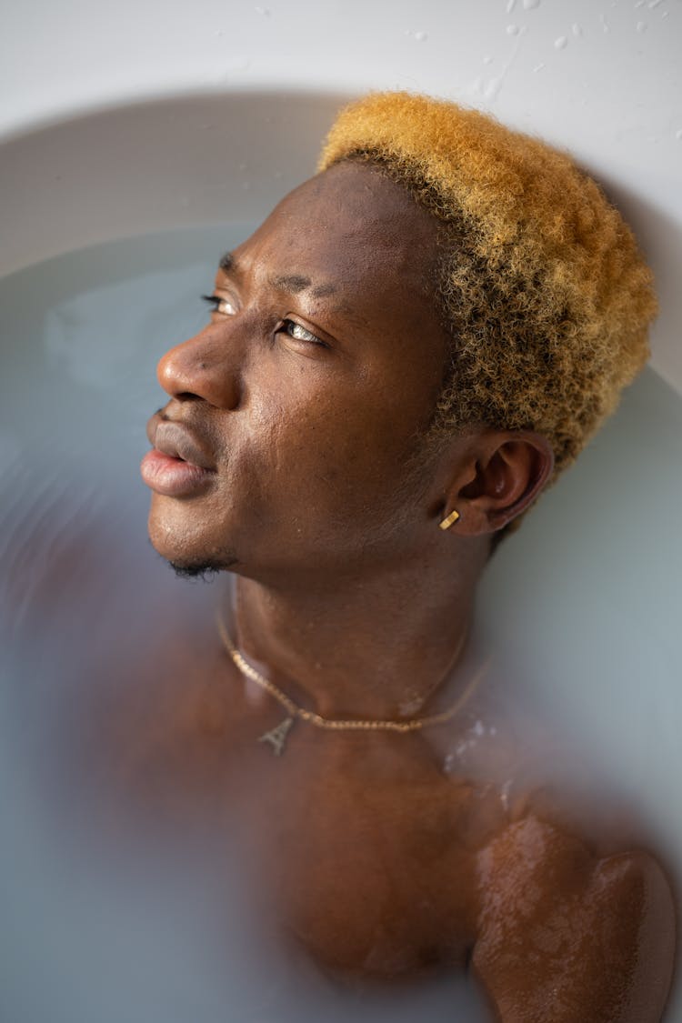 Pensive Black Man Lying In Bath