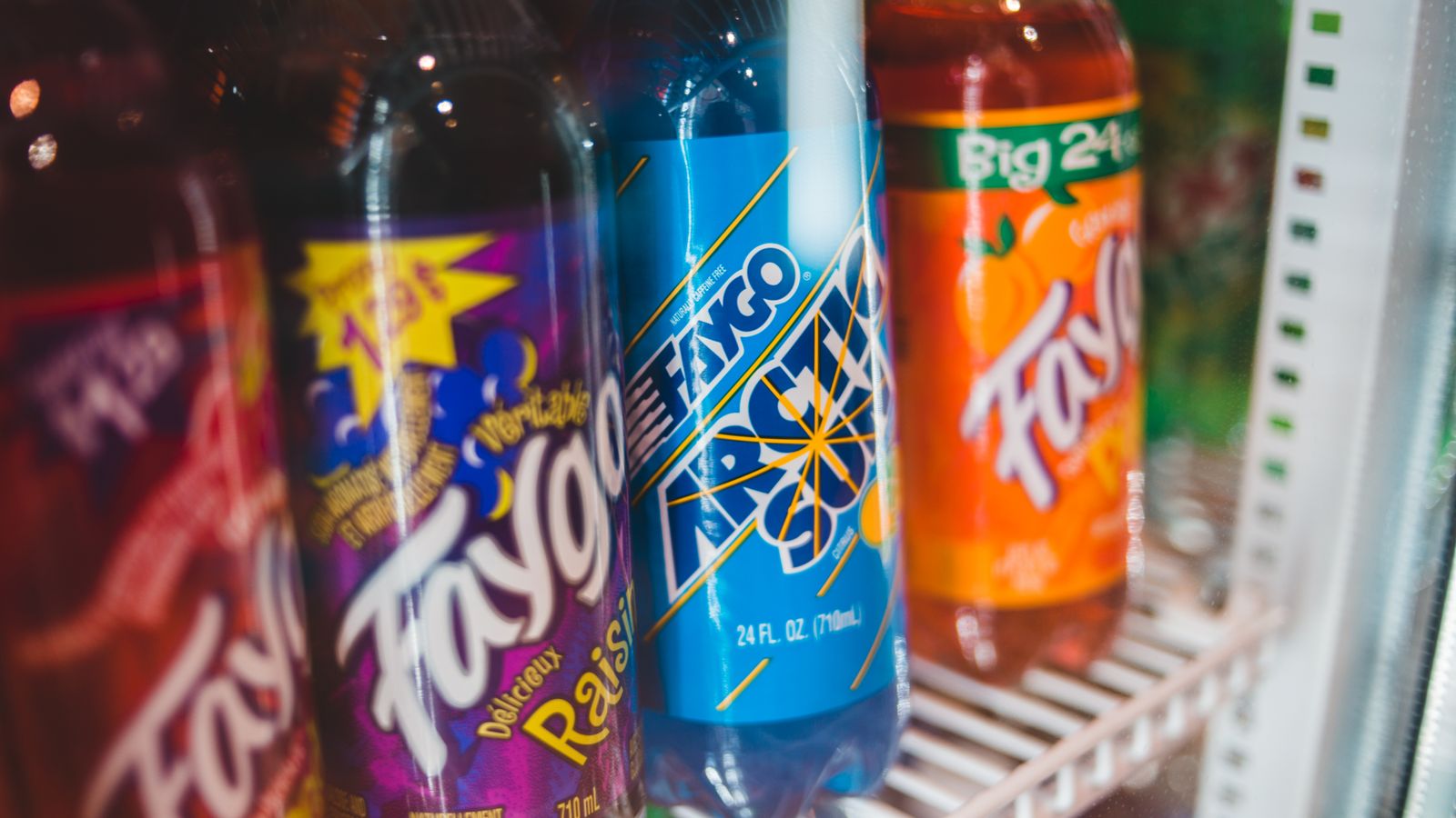 Close-up of assorted Faygo soda bottles in a refrigerated grocery store display.