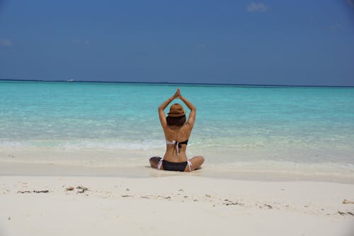 Woman in Black and White Bikini Taking Up Yoga Near Seashore during Daytime