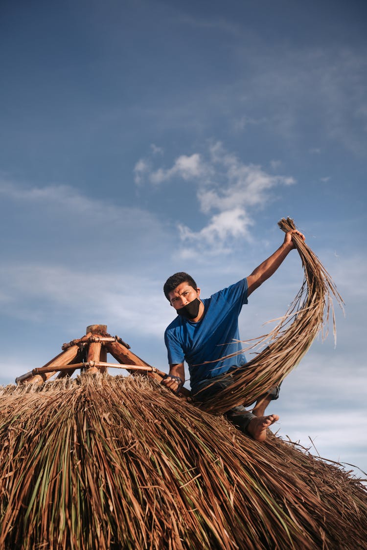 Man On Roof Of Palapa