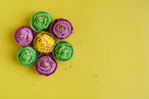 Free Colorful Cupcakes On Yellow Background Stock Photo