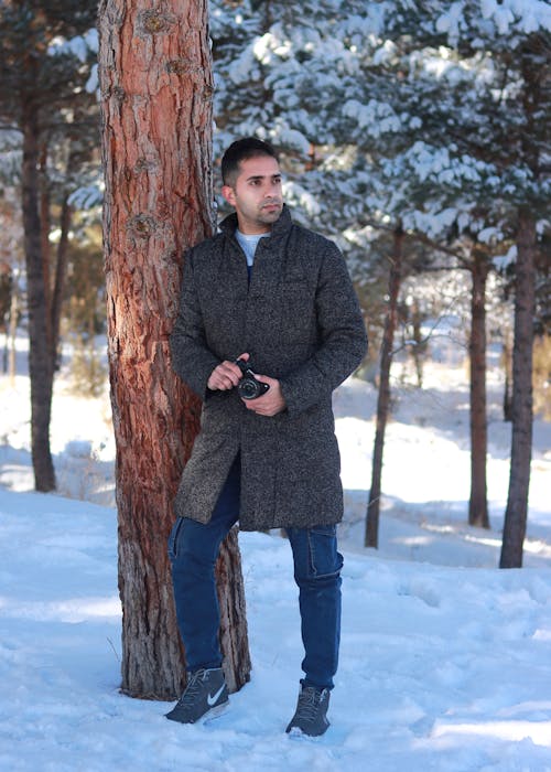 A Man in Coat Holding a Camera
