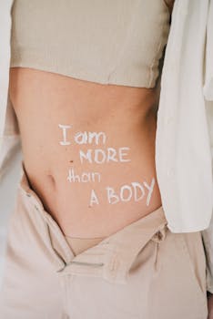 Close-up of a woman's torso with empowering text promoting body positivity.
