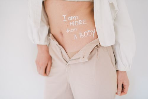 Free Close-up of a woman with a feminist message on her body, promoting body positivity and empowerment. Stock Photo