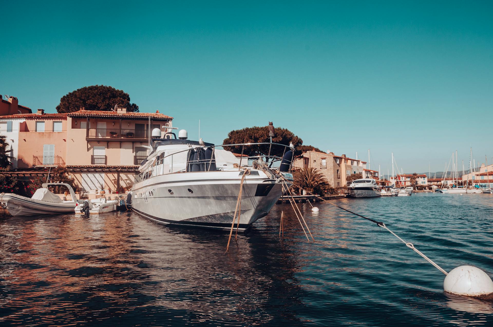 A luxurious yacht moored at Grimaud Marina, Provence-Alpes-Côte d'Azur, on a sunny day.